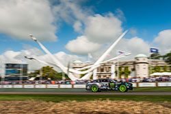 No Downton Abbey here. JR powers past the stately Goodwood Manor House and the massive display of this year's event sponsor

